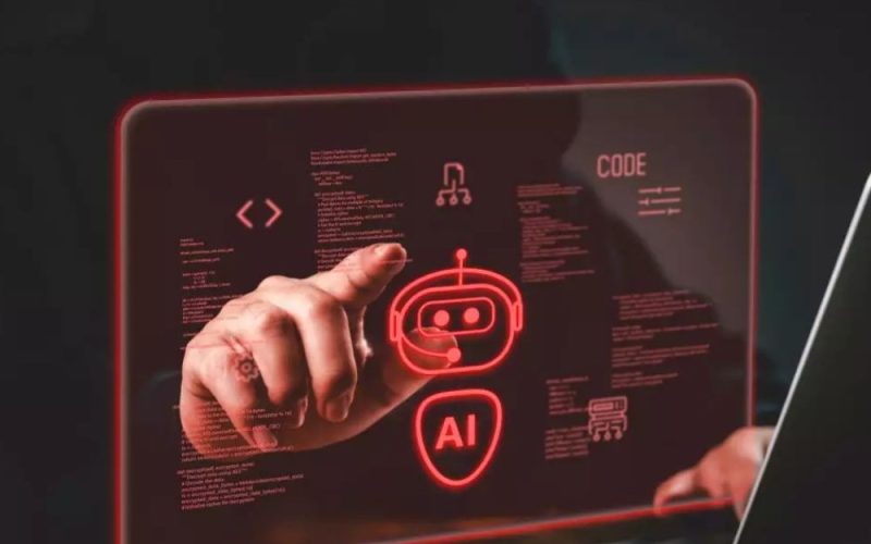 En person pekar på en digital röd hologramdisplay med AI-symboler och kod framför en laptop.